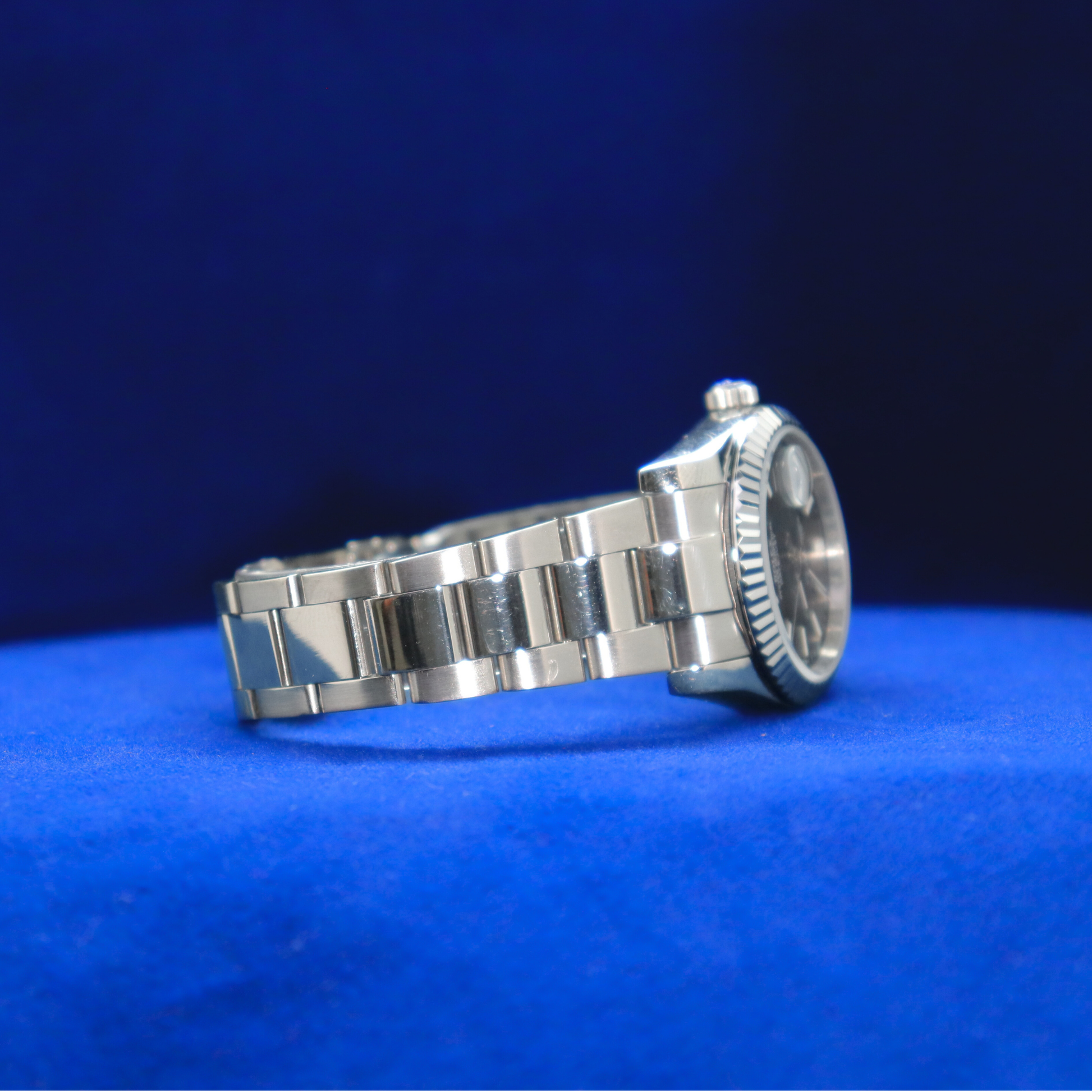 Right side view of sleek gunmetal grey dial watch, half iced out custom piece with modern silver finish