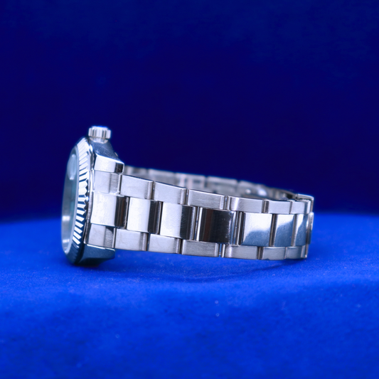 Left side view of half iced out custom sleek blue dial watch featuring metallic accents and minimalist styling