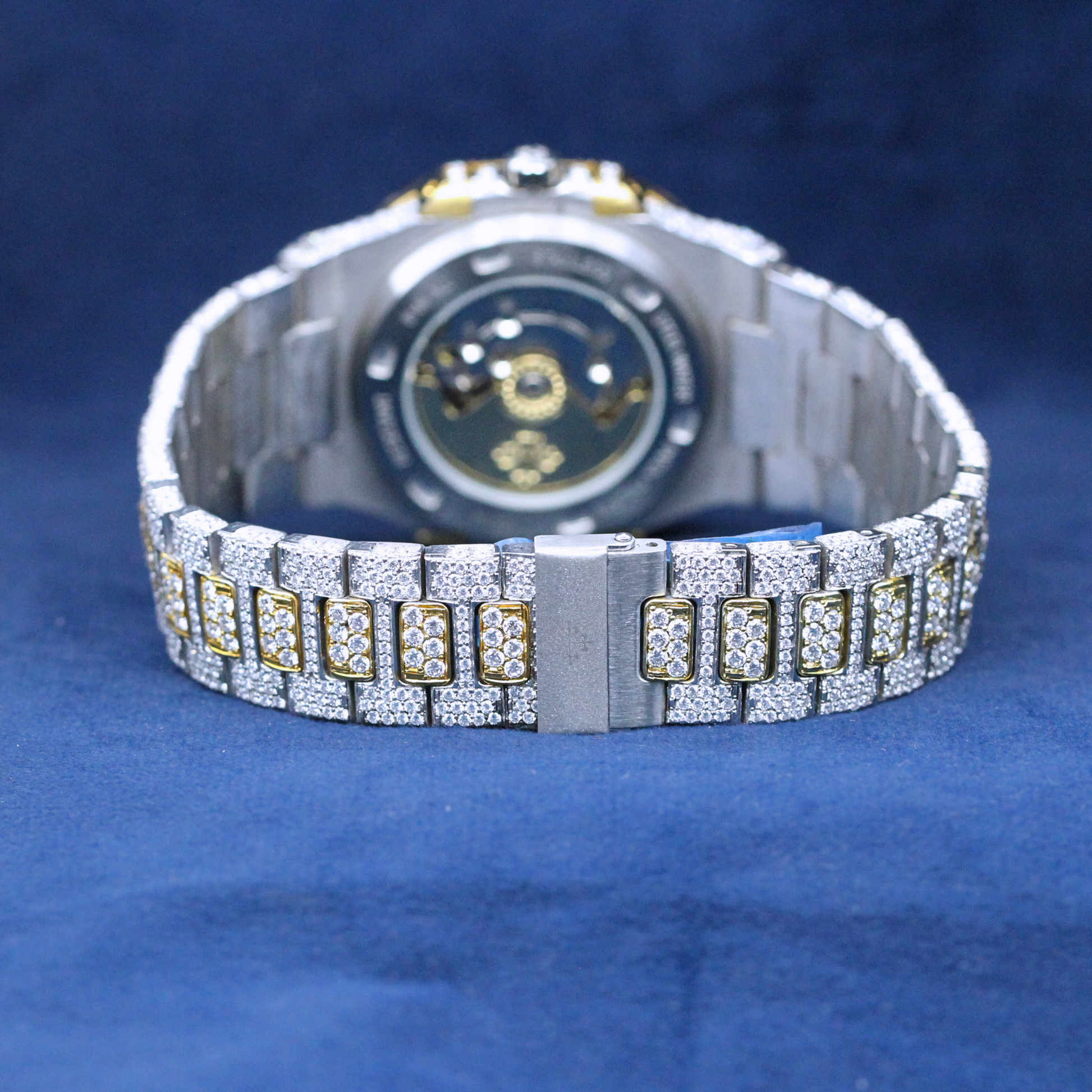 A back-side view of a custom iced-out hip-hop watch in a two-tone gold and silver finish, highlighting the polished case and high-end craftsmanship.