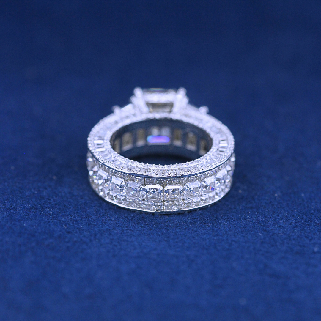 A back-side view of a hip-hop jewelry total iced-out ring in 925 sterling silver, highlighting the polished band with an extravagant diamond-encrusted design."