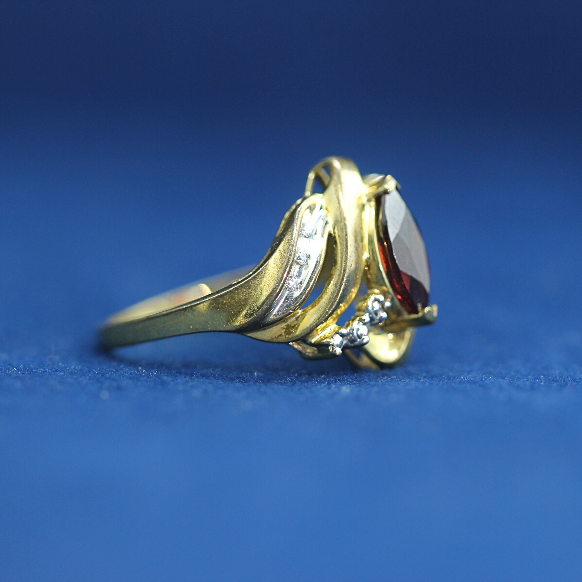 Right side of preowned garnet ring in 14K silver with sparkling moissanite – elegant piece that matches half iced out custom jewelry collections.