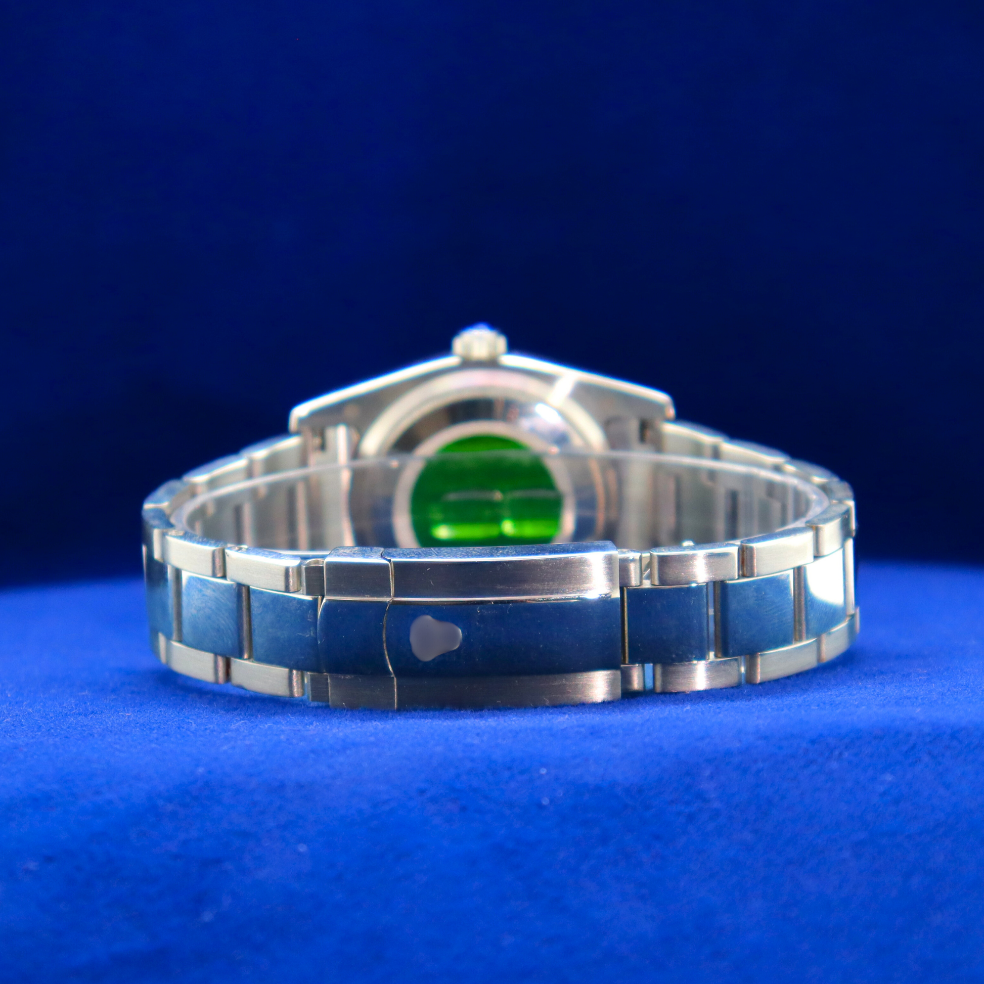Back view of sunburst black-green dial half iced out custom watch, showcasing fine stainless steel craftsmanship