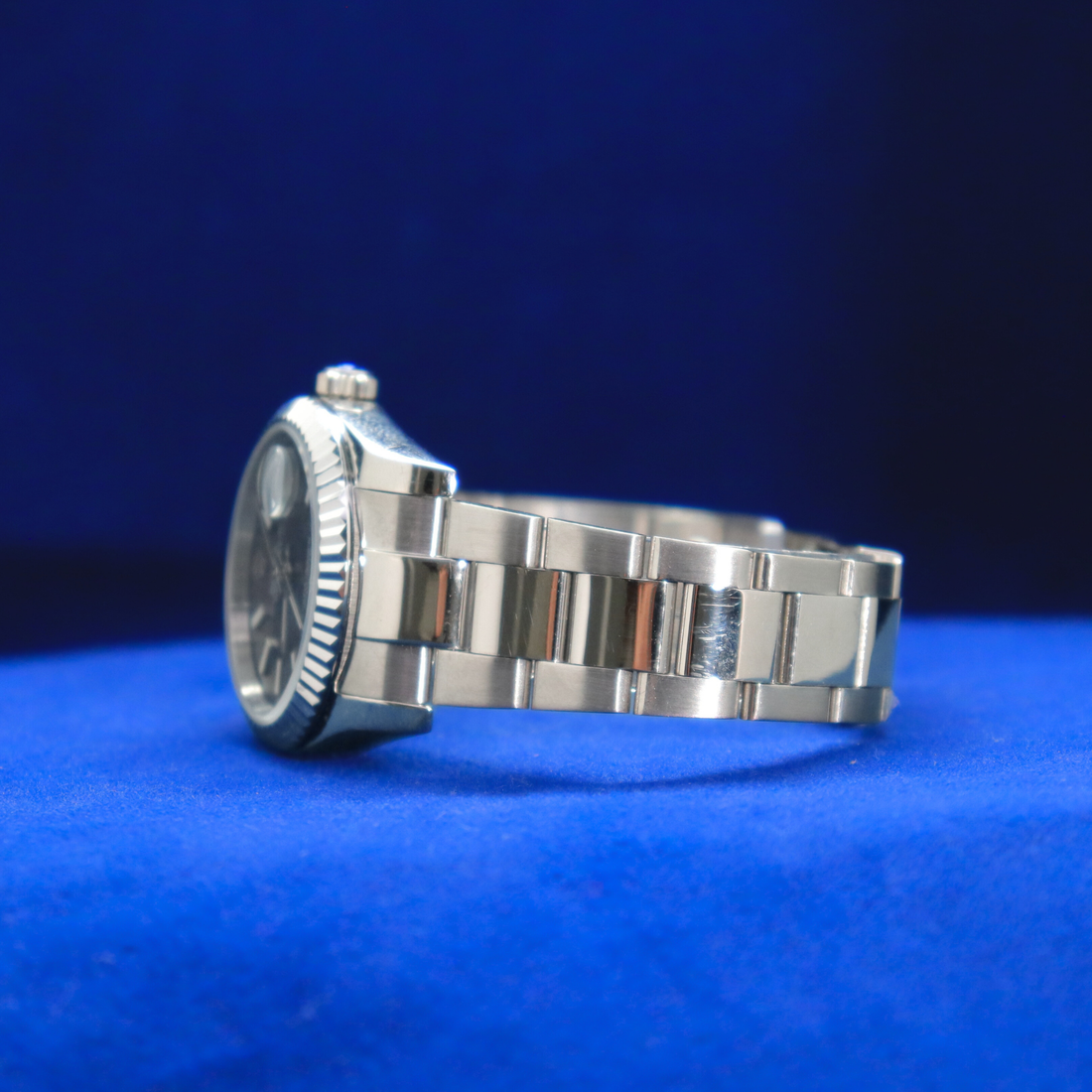 Front view of sleek gunmetal grey dial half iced out custom watch with minimalist luxury design

